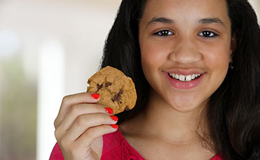 Una muchacha con una galleta de chocolate